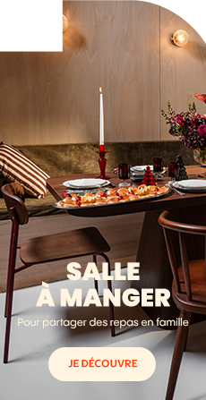Table de salle à manger dressée avec assiettes, verres, bougies et bouquet de fleurs dans une ambiance chaleureuse